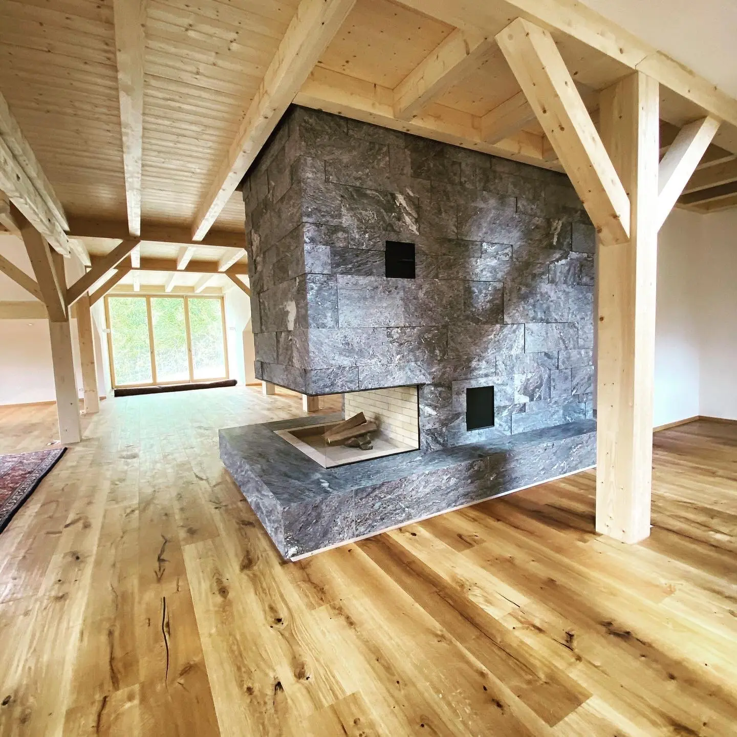 Kamin im Wohnraum mit Holzbalken — Landhaus Allgäu — STOI