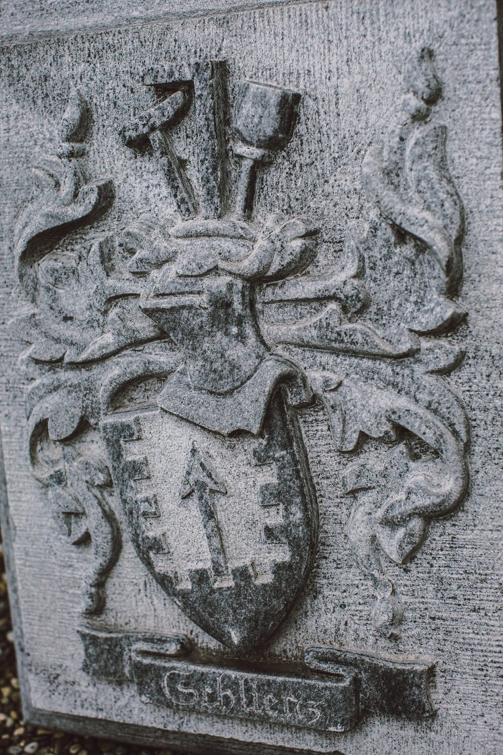 In Stein gehauenes Wappenrelief mit dem Namen Schlienz und Steinmetzwerkzeug