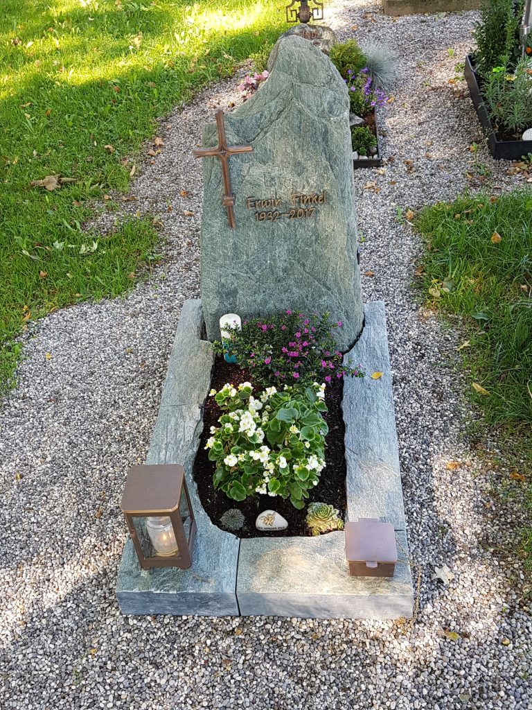 GrÃ¼ner Serpentinit-Felsgrabstein in massiver organischer Form mit Metallkreuz und passender Grabanlage