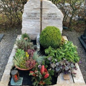 Zweiteiliges Doppelgrab aus zwei naturbelassenen Kalkstein-Felsstücken auf dem Friedhof – STOI Steinmetzwerkstatt