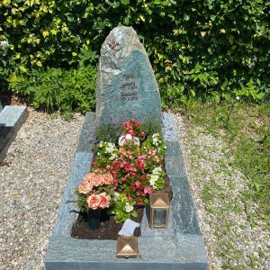 Felsengrabstein aus dunkelgrünem Naturstein mit natürlicher Spaltbruchoberfläche und Goldschrift