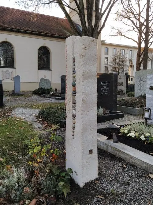 Helle Naturstein-Stele mit integrierten Kieselsteinen und farbigem Akzentelement, STOI Steinmetzwerkstatt