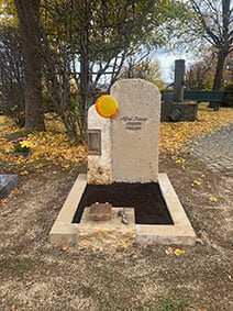 Kalkstein-Grabstein mit organischer Apfelbaumform und eingebettetem bernsteinorangen Glas-Sonnenelement
