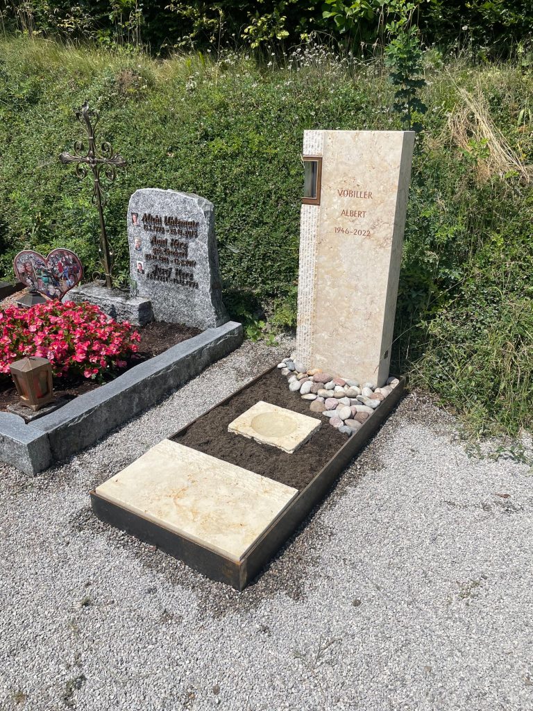 Cremweiße Kalkstein-Stele mit gestockter Oberfläche und seitlich integrierter beleuchteter Laterne