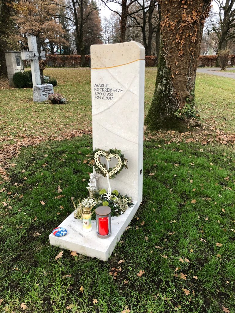 Hohe weiße Kalkstein-Stele mit goldener Diagonallinie – handwerklich von STOI Steinmetzwerkstatt