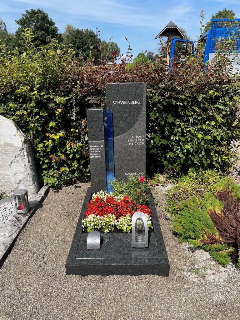 Grauer Granit-Grabstein in Stelenform mit vertikalem leuchtendem Blauglas-Streifen, handwerklich von STOI