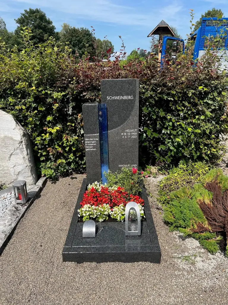 Grauer Granit-Grabstein in Stelenform mit vertikalem leuchtendem Blauglas-Streifen, handwerklich von STOI