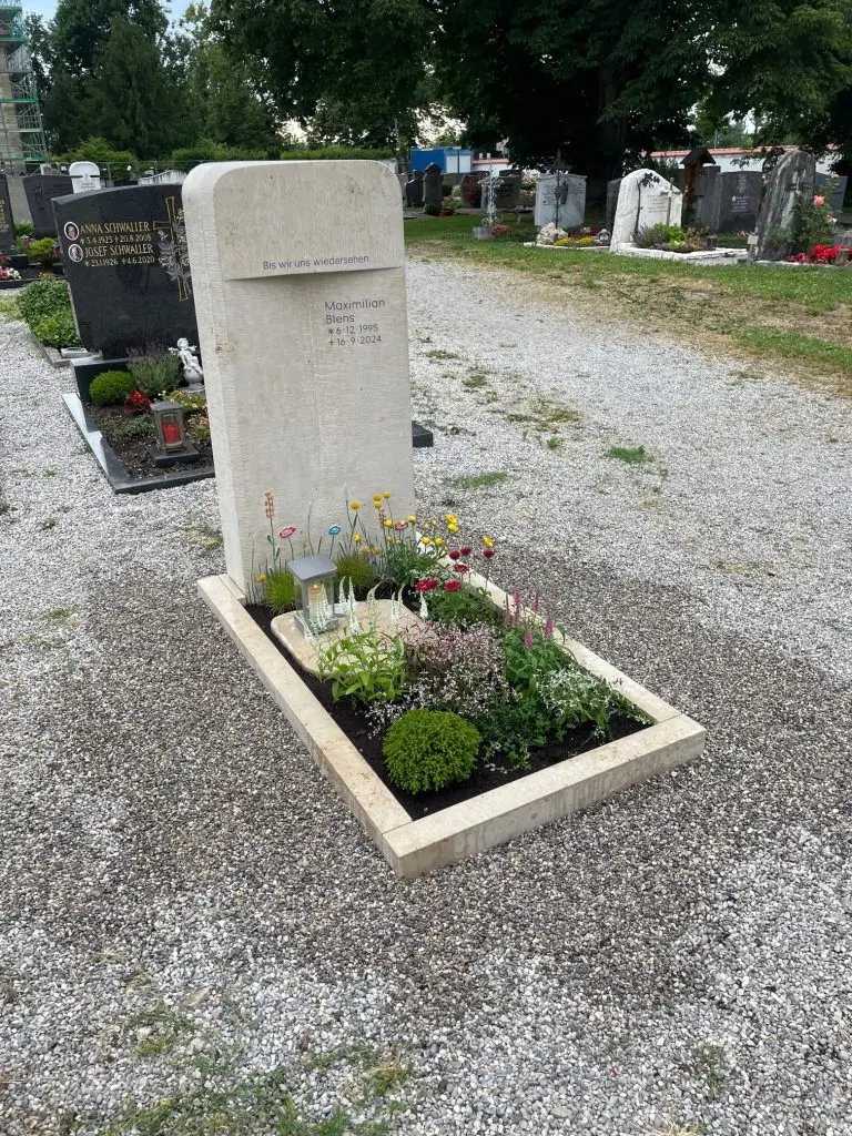 Helle Kalkstein-Stele mit farbig gestaltetem Blumenwiesenmotiv in Gelb, Rot und Rosa, STOI Steinmetzwerkstatt
