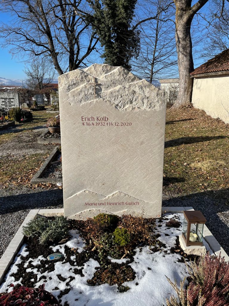 Kalkstein-Grabstein mit natürlichem Spaltbruch, Kreuzstich-Textur und roter Inschrift von STOI Steinmetzwerkstatt
