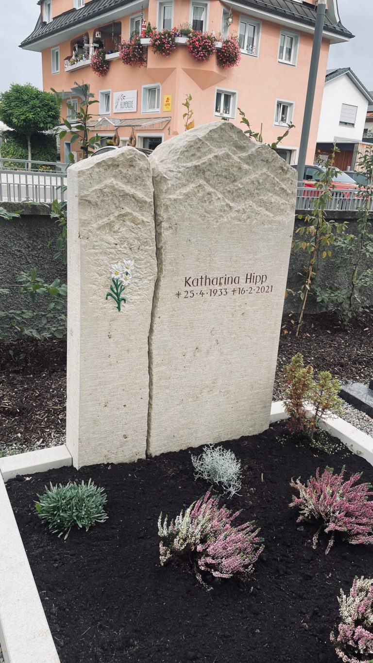 Zweiteiliger cremefarbener Kalkstein-Grabstein mit Bergpanorama-Silhouette und farbigem Enzian-Motiv