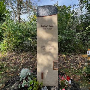 Doppelgrabstein aus warmem Sandstein mit handgemalten Tusche-Lauben-Motiven und integriertem Kerzenhalter