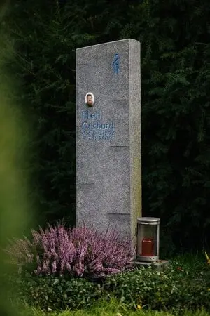 Schlanke Granit-Stele mit blau graviertem Violinschlüssel und runder Fotoplakette für Musikliebhaber