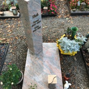 Hohe polierte Granit-Stele mit farbiger Maserung in Rosa und Grau sowie Bronzeschrift von STOI