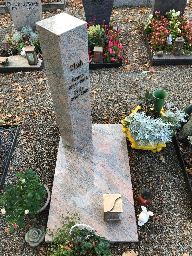 Hohe polierte Granit-Stele mit farbiger Maserung in Rosa und Grau sowie Bronzeschrift von STOI