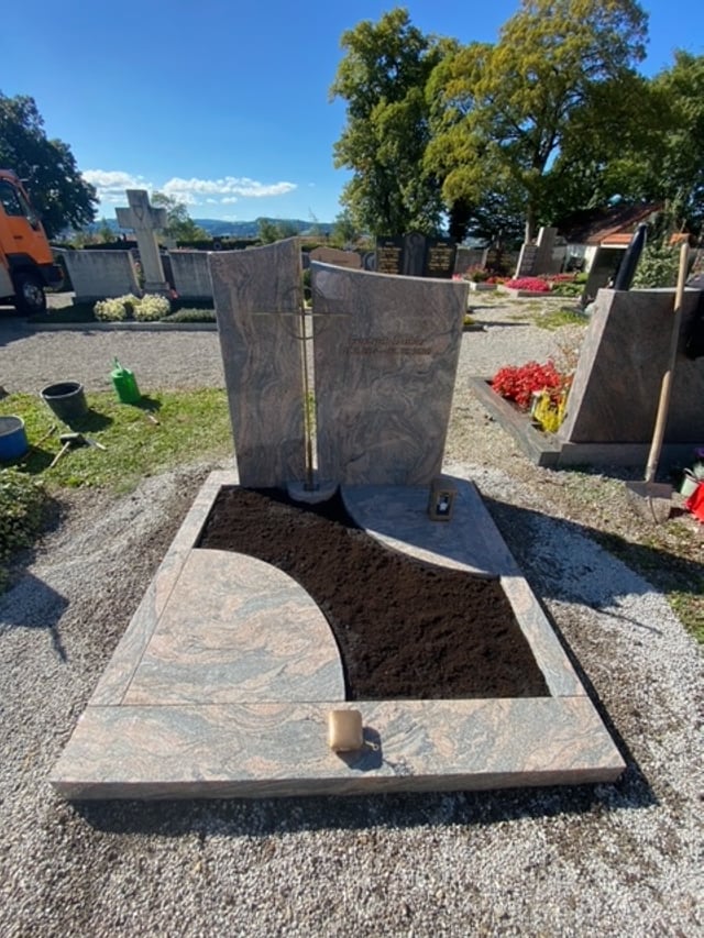 Polierter Grabstein aus Multicolor-Granit mit rundem Lichtdurchbruch und warmen Rosé-Braun-Tönen