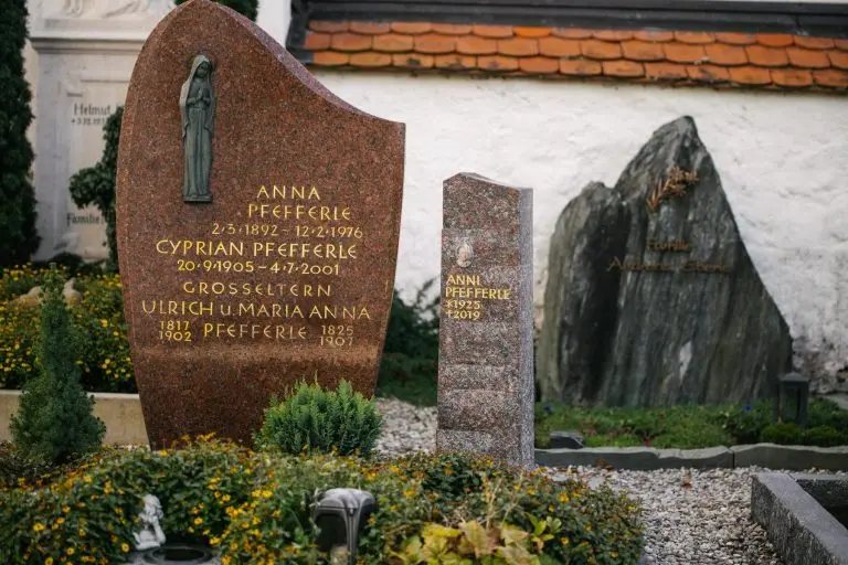 Schlanke polierte Granit-Stele in Rot neben bestehendem Familiengrabstein auf historischem Friedhof