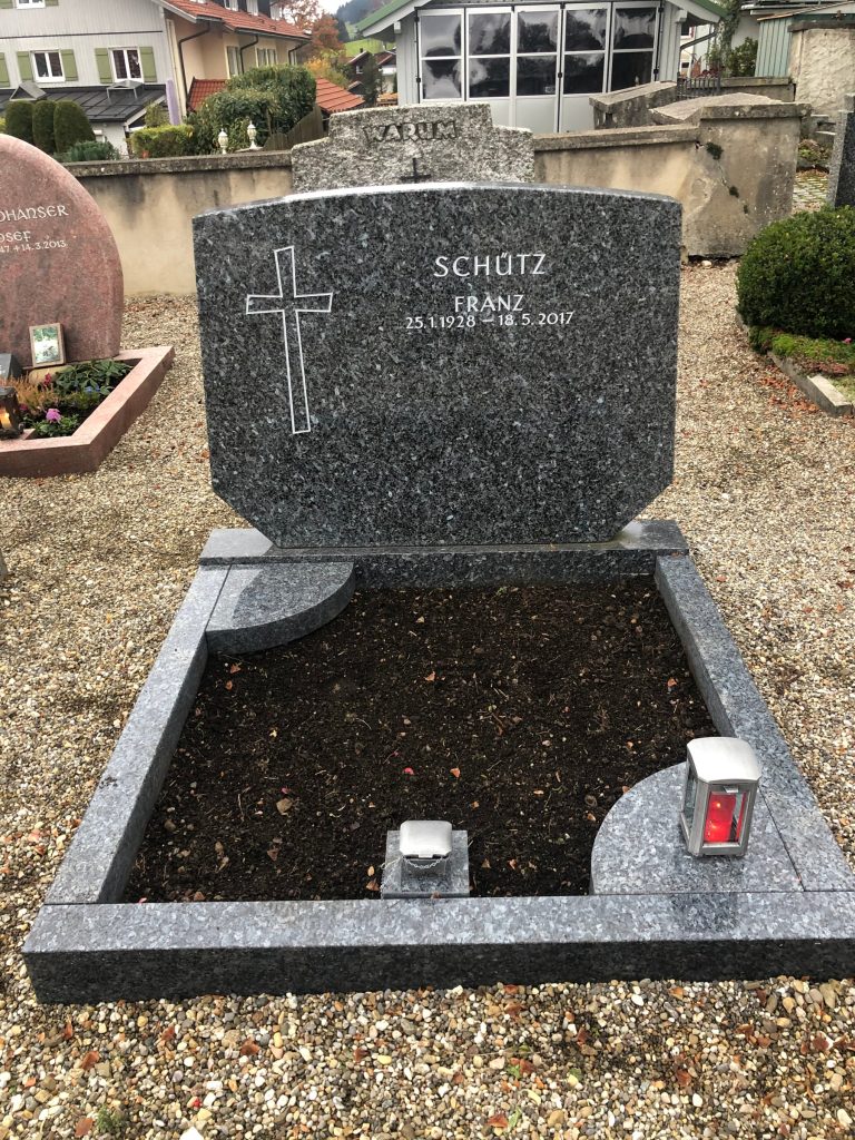 Polierter dunkelgrauer Granit-Grabstein mit konkavem Bogenabschluss und eingravierten Kreuz, Hochglanzpolitur