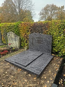 Anthrazit-Granit-Doppelgrabstein mit polierter Oberfläche und flacher Grabeinfassung von STOI Steinmetzwerkstatt
