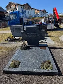 Polierter Granit-Doppelgrabstein mit eingearbeitetem Kreuzzeichen und abgerundeten Ecken