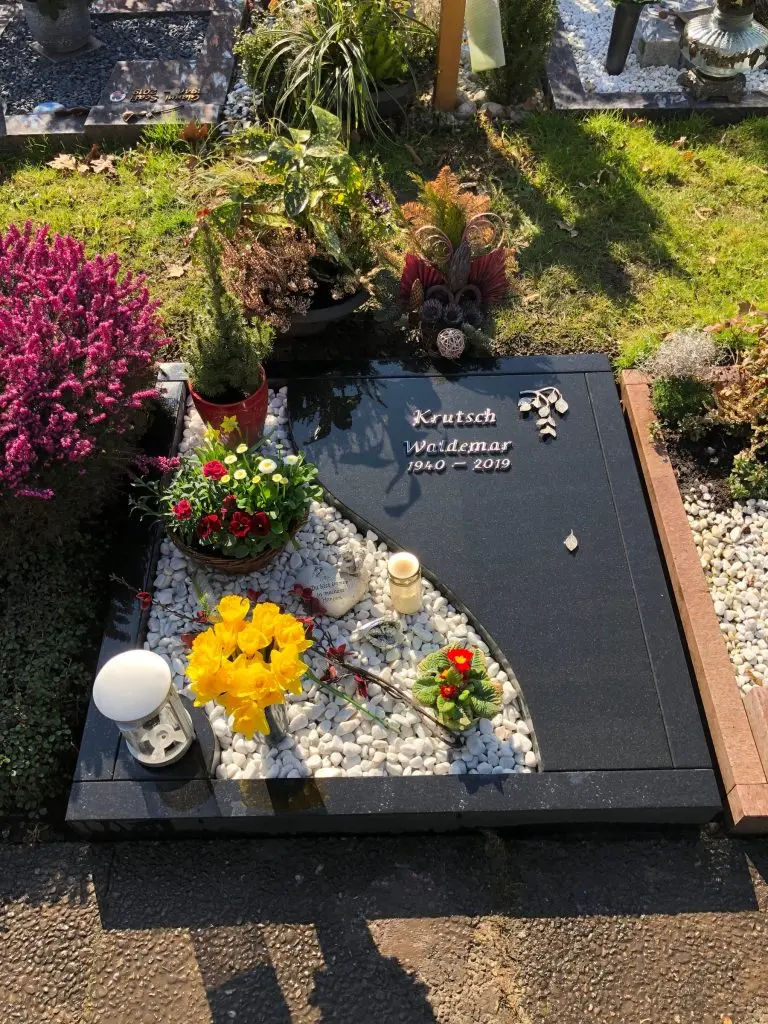 Polierter dunkelgrauer Granit-Liegestein fÃ¼r Urnengrab mit geschwungenem Bogendurchbruch und Schriftgravur