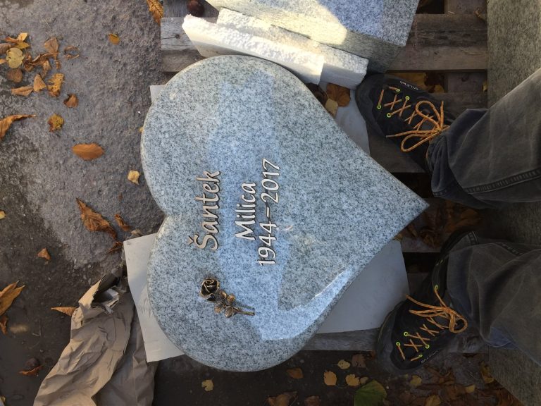 U 534 | Herzförmiger Urnengrabstein aus hellem Granit mit Bronzerose