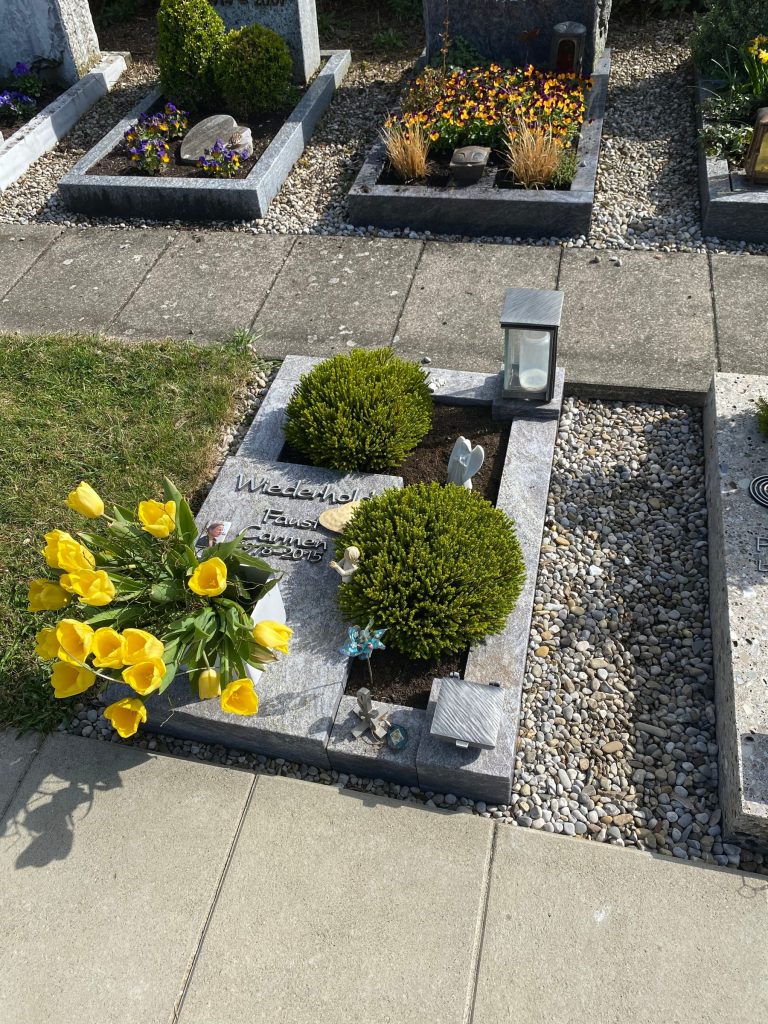 Urnengrab-Liegestein aus anthrazitfarbenem Granit mit Steinrahmung von STOI Steinmetzwerkstatt