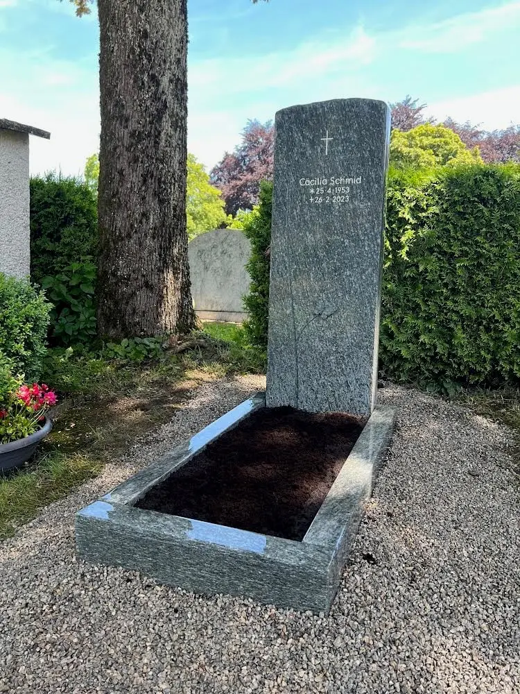 Polierter Granit-Urnengrabstein in Blau-Grau-Grün mit Kreuzgravur – handwerklich von STOI Steinmetzwerkstatt
