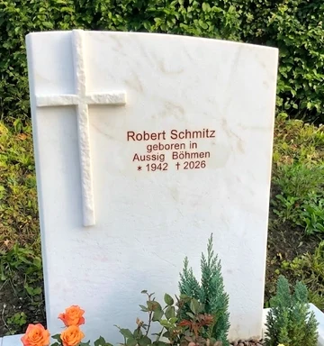 Aufgestelltes Grabmal aus weißem Marmor mit Kreuz auf dem Friedhof